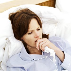 Sick Young Woman Lying in Bed