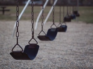 A set of empty black swings in a line