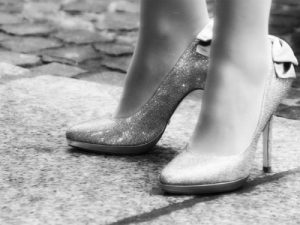 Standing on your own two heels - A grayscale picture of two high heels with a woman standing in them.
