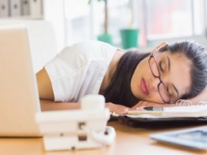 tired woman sleeping at her desk featured