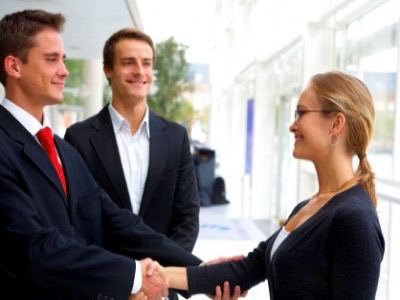 business men shaking womans hand featured