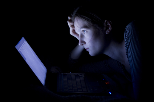 woman on computer in the dark, revenge porn